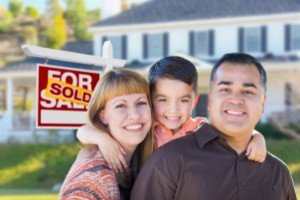 Sell my house fast Houston | Young Family in Front of Sold Real Estate Sign House